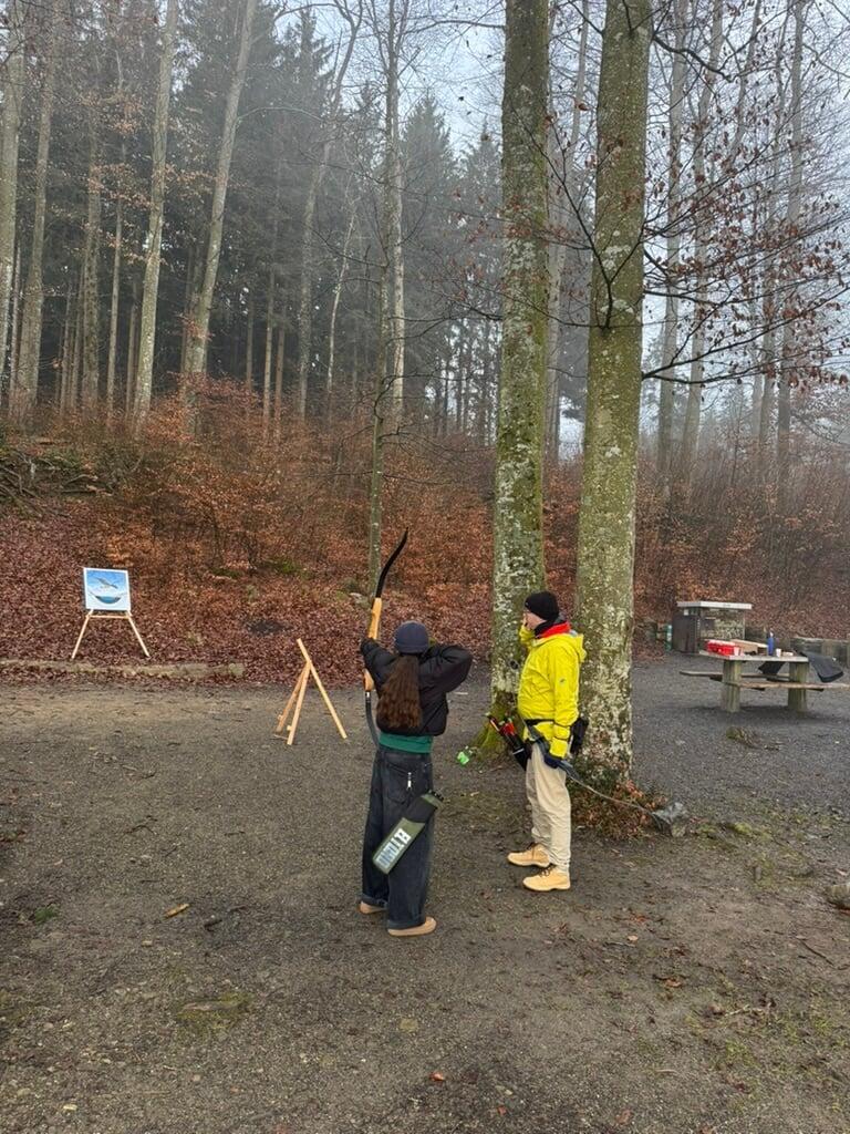 Roger Sigrist, leitet eine Jungedliche im Bogenschiessen an. 