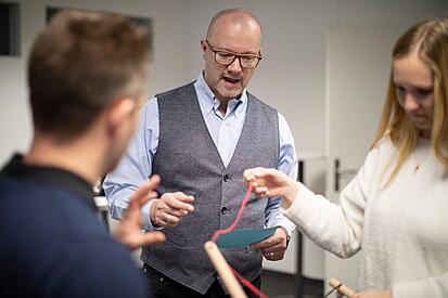 2 Personen halten das Tool "Unmögliche Stäbe" in den Händen. Supervisor Roger Sigrist erklärt die Funktion